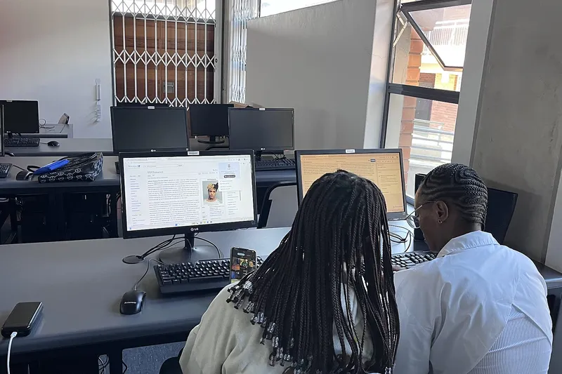 Two students working at computers in a university lab